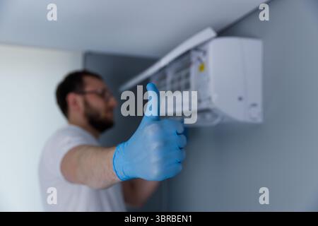 Skilled Technician Giving Approval After Successfully Installing a New Air Conditioning Unit for Optimal Cooling in a Modern Home Environment Stock Photo