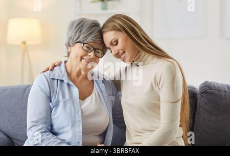 Happy adult woman embracing her senior grey haired mother Stock Photo