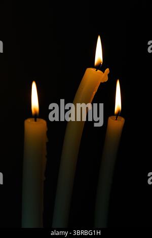 Three Elegant Candles with Gentle Flame Flickering in the Dark, Creating a Soothing and Serene Atmosphere Perfect for Relaxation and Reflection Stock Photo