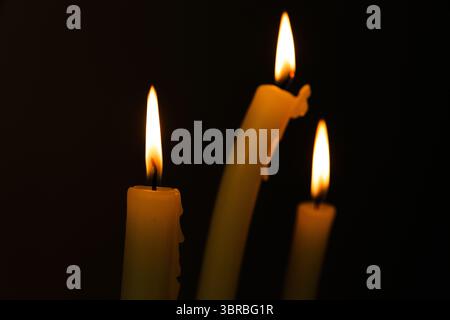 Three Illuminating Candles Dancing in the Dark, Creating a Warm and Inviting Atmosphere Perfect for Intimate Gatherings and Relaxing Moments of Stock Photo