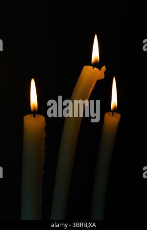 Three Elegant Candles with Gentle Flame Flickering in the Dark, Creating a Soothing and Serene Atmosphere Perfect for Relaxation and Reflection Stock Photo