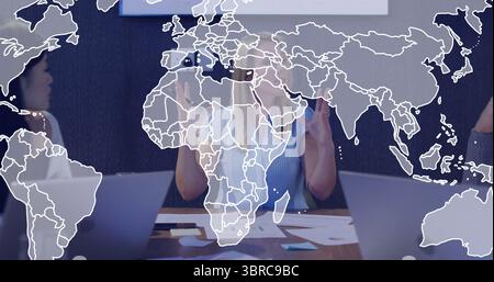 Business team in business attire discussing project at conference table, with laptops and charts Stock Photo