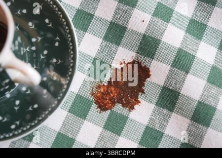 Coffee spill on a green and white checkered tablecloth Stock Photo