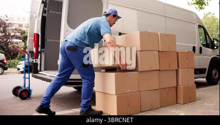 Man Unloading Boxes From Van For Removal And Delivery Service. Stock Photo