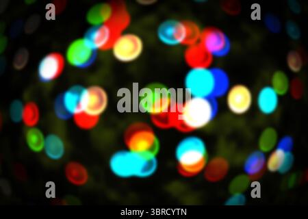 Cluster of defocused colored light circles is floating in bokeh effect over dark backdrop Stock Photo