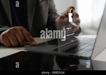 A cybersecurity data privacy image shows person using laptop with digital overlay of login form and padlock icon, symbolizing cybersecurity Stock Photo