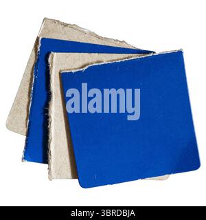 Multiple layers of blue and gray square paper on white background with clipping path. Papers are torn from box packaging. Stock Photo