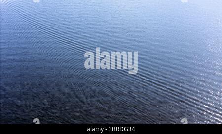 Aerial view of the water's surface, rippling with a mesmerizing pattern of light and shadow, creating an abstract seascape, Marlborough Sounds, New Zealand. Stock Photo
