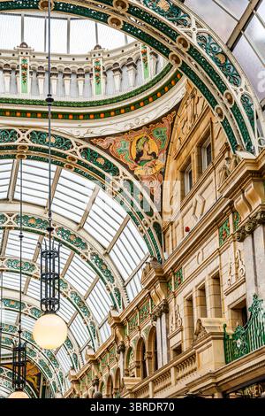 Interior view of County Arcade, a richly decorated Victorian shopping arcade with glass domes, pink marble columns and luxury stores in Leeds, UK Stock Photo