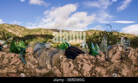 Pieces of glass used a protection in rural houses, cemented at the edge of the wall, with the landscape as a background, in the town of Sora, in the e Stock Photo