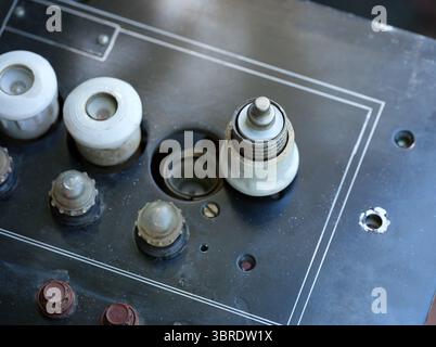 White ceramic plug fuse on an old black electrical panel Stock Photo