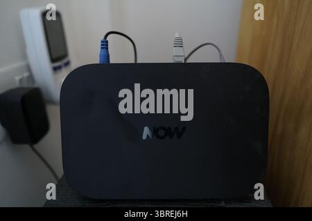 Black Broadband Router With Multiple Cables Connected on a Table. Dorking, England Stock Photo
