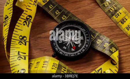 Compass and Measuring Tape on Wooden Table Stock Photo