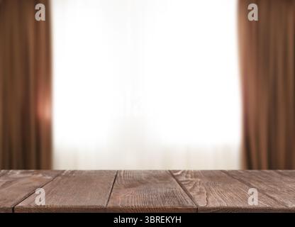 Empty wooden table against window with curtains in room Stock Photo
