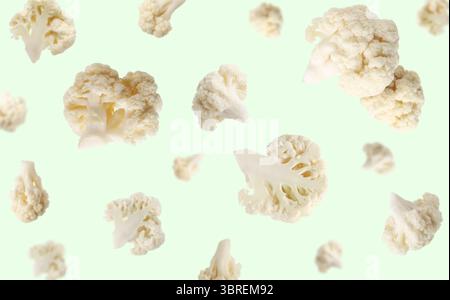 Fresh cauliflower florets falling on light green background Stock Photo