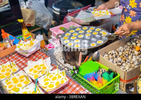 Street vendor cooking fried quail eggs, stall in Bangkok, thailand Stock Photo