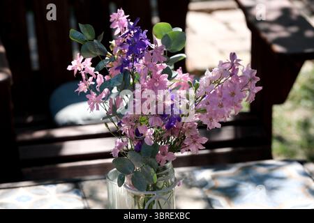 A vibrant bouquet of pink and purple flowers brings joy to a sunny outdoor setting. Stock Photo