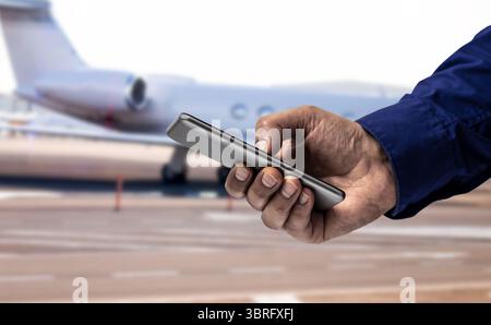 Hand of a businessman at airport, smartphone and travel with communication, airplane for business trip.Waiting for flight with transportation, journey Stock Photo