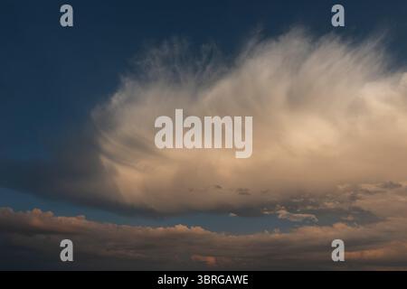 a beautiful picture of clouds, feathery clouds in the light of the setting sun, fluffy cloud against the blue sky Stock Photo