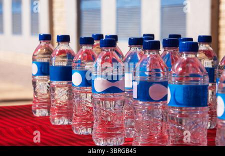 several bottles of bottled still water on a table, arranged in symmetry Stock Photo
