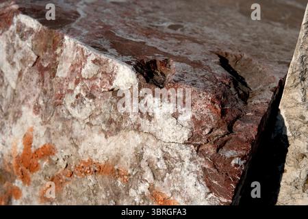 Sunlit textured rock glimmers, showcasing its vibrant colors and patterns. Stock Photo