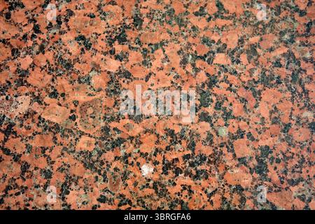 Close-up of polished red granite highlighting its unique textures. Stock Photo