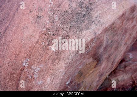 Intricate patterns on weathered rock reveal nature's artistry at sunset. Stock Photo