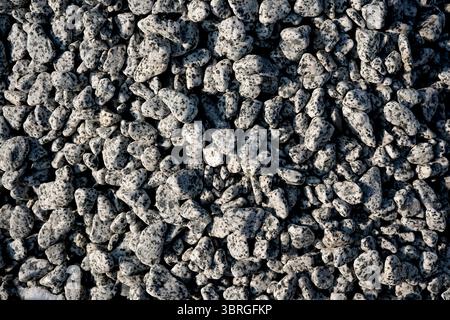 A close-up view of small gray stones scattered on the ground shows texture. Stock Photo