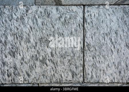Light dances across a rugged granite surface with unique swirls and lines. Stock Photo