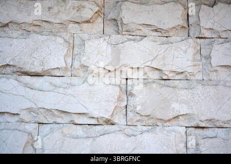 Natural light enhances the smooth surface of a polished stone wall. Stock Photo