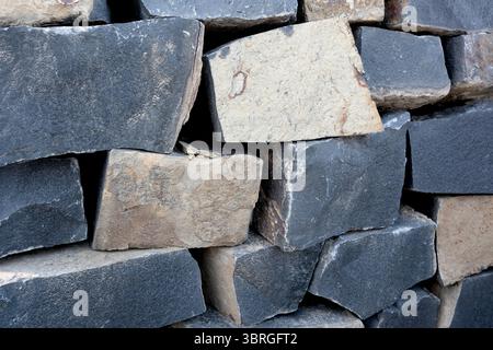 Rough stones of varying colors form a stylish wall, showcasing nature's art. Stock Photo