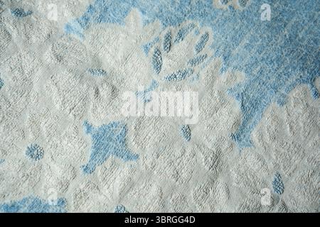 Soft blue fabric adorned with intricate white floral designs creates elegance. Stock Photo