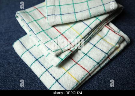 Soft kitchen towels in vibrant grids arranged together on a dark background. Stock Photo