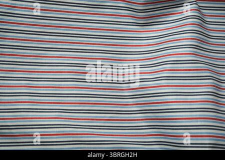 Vivid lines of blue, red, and white weave together in this fabric design. Stock Photo