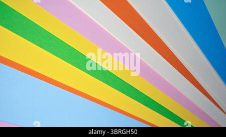 Brightly colored paper strips create a dynamic burst of energy on a wall. Stock Photo