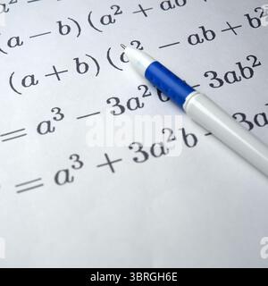 A close-up of algebraic equations written on lined paper with a pen. Stock Photo