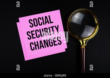 Social Security Changes text on sticky note with magnifying glass on black background Stock Photo