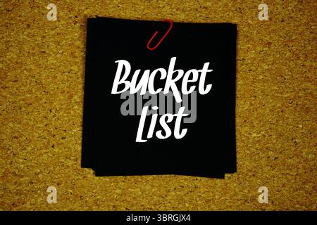 Bucket List text message on stick note on cork paper background Stock Photo