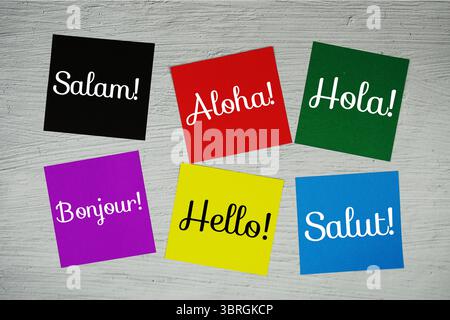 Hello in different languages text on stick note on concrete background Stock Photo