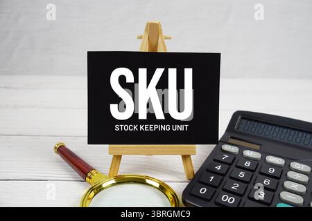 SKU Stock Keeping Unit text with magnifying glass and calculator on wooden background Stock Photo