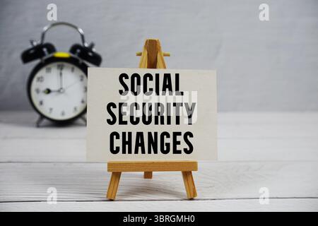 Social Security Changes text with easel and alarm clock on wooden background Stock Photo