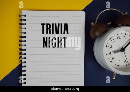 Trivia Night text written on notepad with alarm clock on yellow background Stock Photo