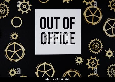 Out of Office text on paper and gear on black background Stock Photo