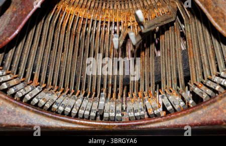 Close up of the typeface of an old rusty typewriter with some of the letters stuck in the up position Stock Photo