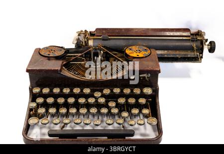 Close up of an old dirty and rusty typewriter on a white background with the concept that the past is gone Stock Photo