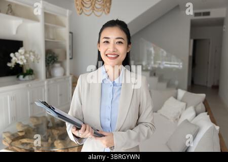 Portrait of smiling young Vietnamese realtor woman Stock Photo