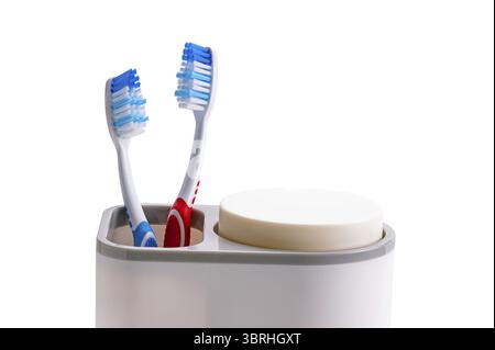 New toothbrushes red and blue handle in plastic holder isolated on white background with clipping path Stock Photo