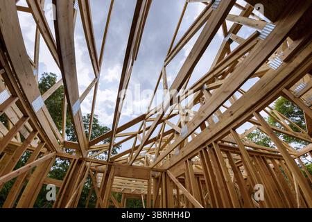 Looking up at new construction beams under a clear blue sky with sunlight Stock Photo