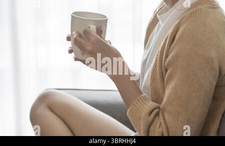 Asian Woman hands holding cup of coffee Stock Photo