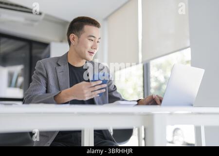Asian Business man working with laptop. Young business man thinking Concentrated at work Stock Photo